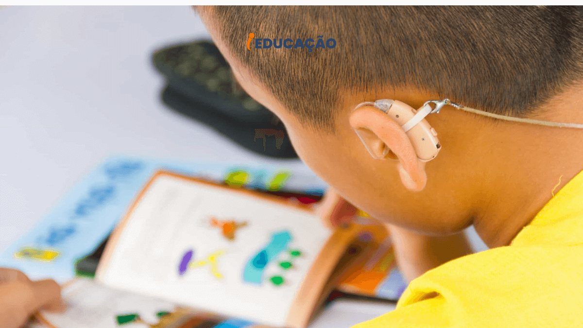 Escola Inclusiva e Escola Especial -  menino com aparelho auditivo fazendo tarefa na escola