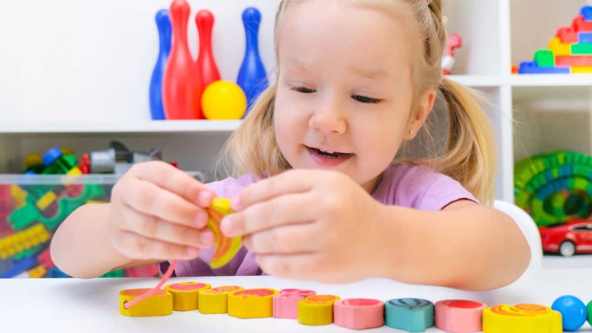 Menina brincando de montar bloco coloridos.