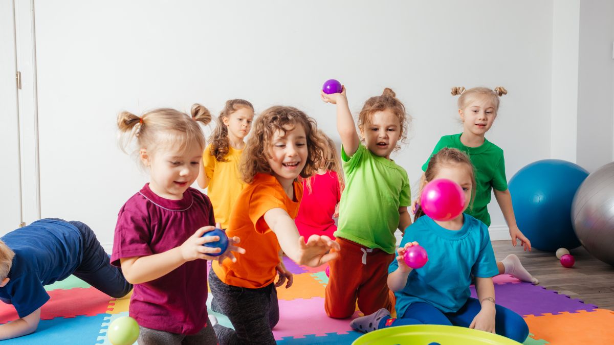 Crianças jogando bolas no cesto. Imagem: Canva Pro