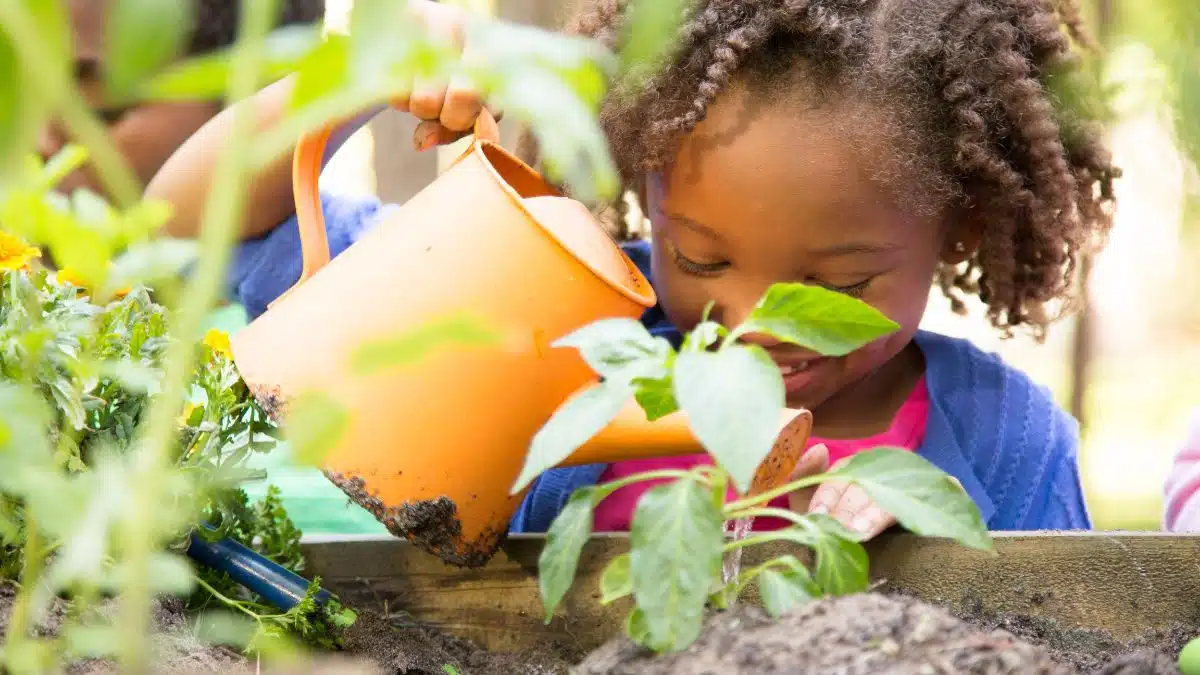 Atividades e Brincadeiras Educativas para Colônia de Férias - iEducação Menina cuidando do jardim.