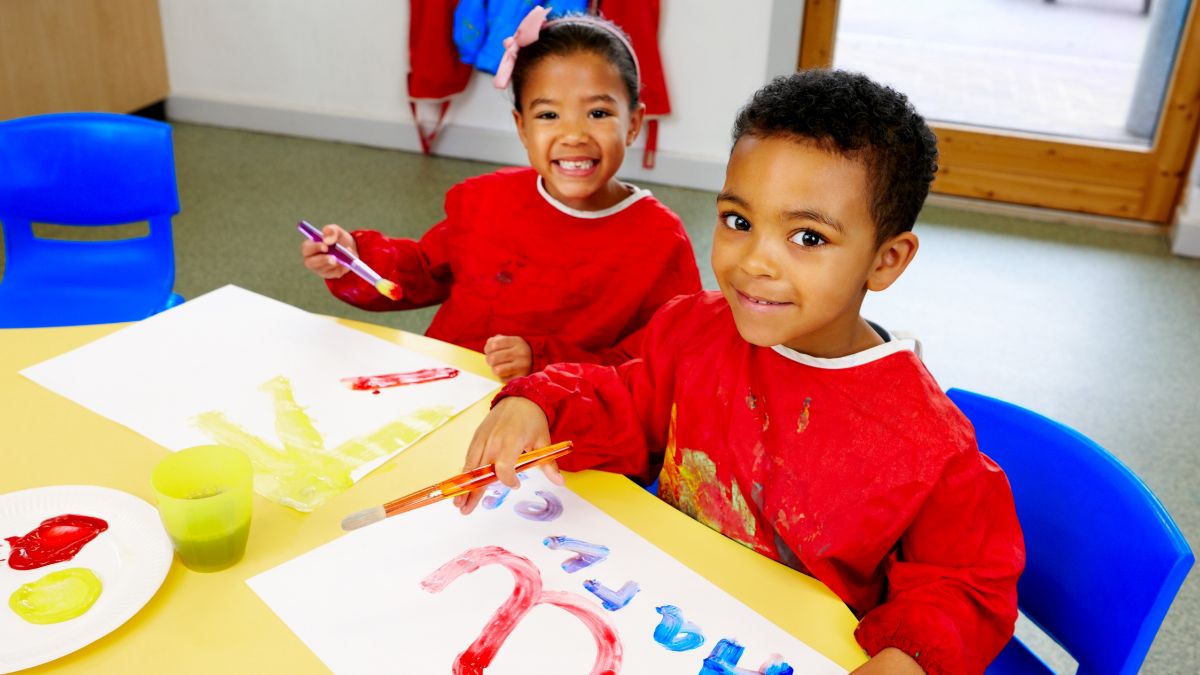 Crianças pintando com tinta guache.
