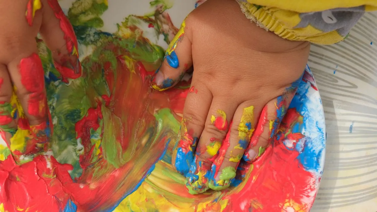 Criança pintando com tinta guache.